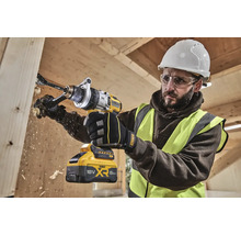 Un meșter găurește o scândură de lemn cu o bormașină fără fir DeWalt