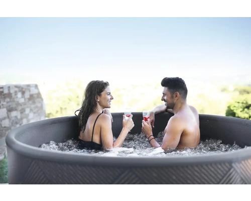 Cuplu se relaxează cu băuturi în cada cu hidromasaj