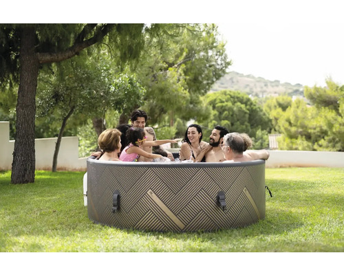 Familie se relaxează într-un jacuzzi gonflabil în grădină.