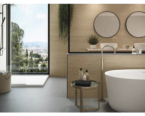 Baie modernă cu duș, cadă și chiuvete în fața unei ferestre mari cu vedere spre oraș.