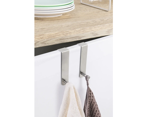 Două cârlige metalice de ușă cu prosoape atârnate de o ușă de dulap