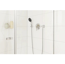 Cabină de duș modernă cu robinet și duș de mână pe un fundal de faianță albă.