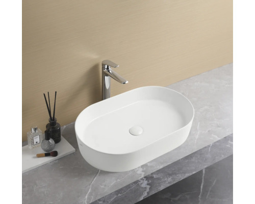 Chiuvetă ovală montată pe blat cu robinet pe un blat într-o baie.