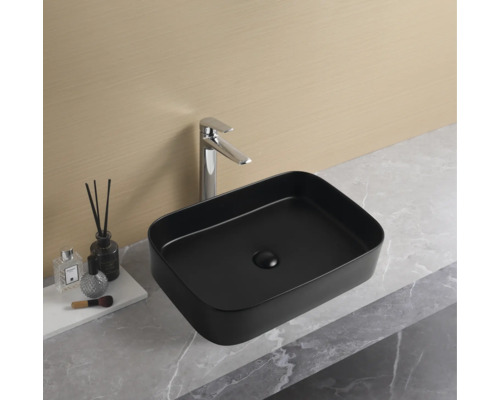 Lavoar ceramic pe blat, de formă dreptunghiulară și de culoare neagră, cu baterie pe un lavoar.