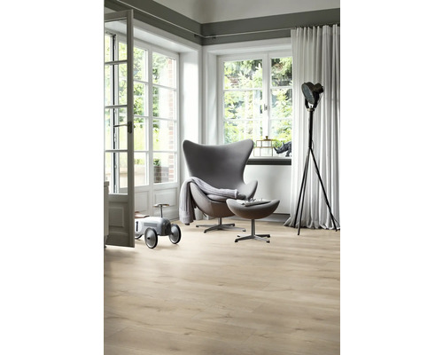 Cameră de zi luminoasă cu fotoliu, lampă de podea și podea din lemn