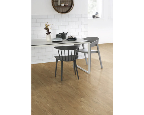 Zonă de luat masa cu podea din lemn, masă și scaune în fața unui perete cu gresie