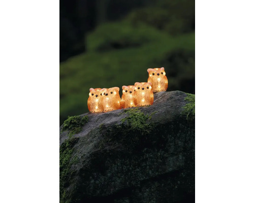 Ghirlandă luminoasă decorativă cu bufnite din plastic, așezată pe o piatră