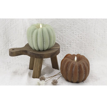 Lumânări decorative de dovleac pe un mic scăunel de lemn și fundal