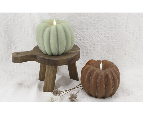 Lumânări decorative de dovleac pe un mic scăunel de lemn și fundal
