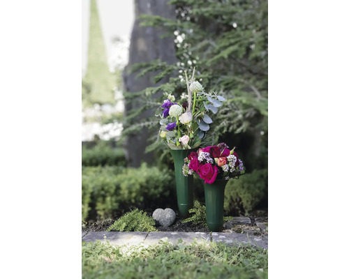 Două vaze funerare cu aranjamente florale și o inimă de piatră pe un mormânt