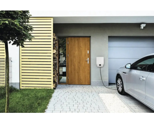 Stație de încărcare pentru mașini electrice pe peretele unei case cu mașină