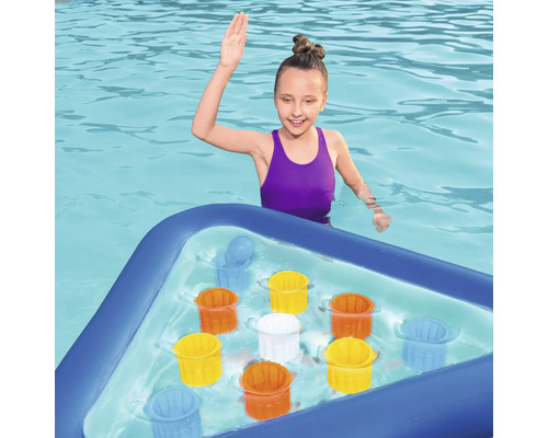 Fată în piscină cu tablă de joc gonflabilă și găleți colorate