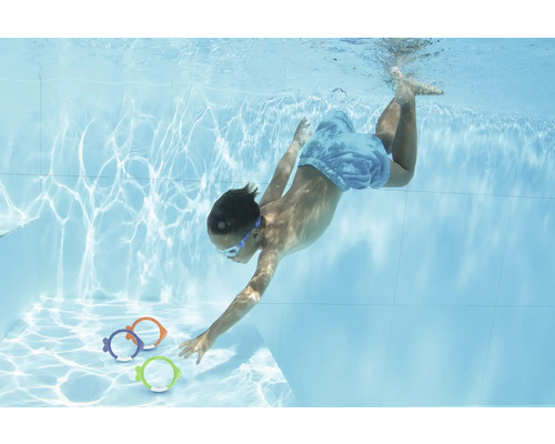 Copil care se scufundă în piscină după jucării în formă de pește