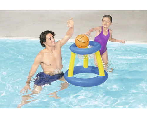 Un bărbat și un copil se joacă cu un coș de baschet în piscină.
