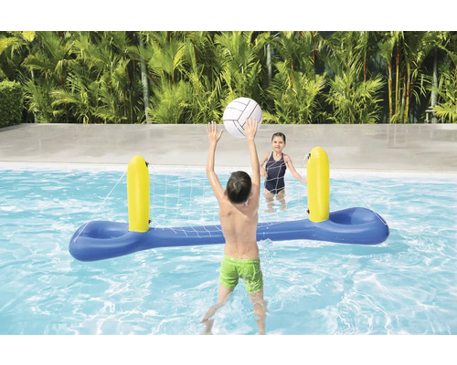 Copii se joacă cu o plasă de volei gonflabilă în piscină.