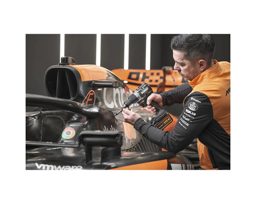 Un bărbat folosește o șurubelniță cu acumulator DeWalt pe o mașină de curse.