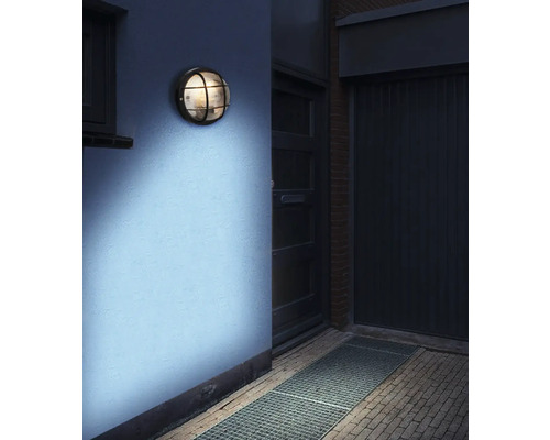 Lumină de perete rotundă cu grilaj montată pe un perete