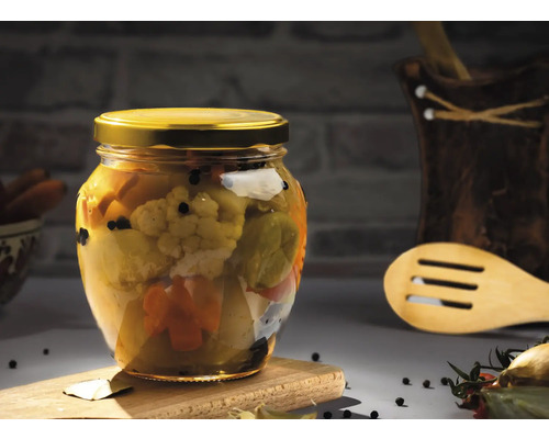 Legume conservate în borcan cu capac auriu pe o scândură de lemn