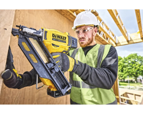 Artizan folosind un aparat de bătut cuie cu acumulator DeWalt pentru fixarea lemnului