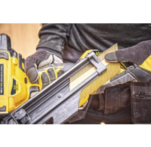 Un muncitor încarcă un pistol de bătut cuie cu cuie în bandă.