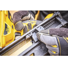 Prim-plan cu un capsator utilizat cu mănuși de lucru