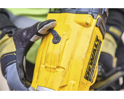 Prim-plan cu o mașină de găurit fără fir Dewalt, cu o mână care acționează un comutator.