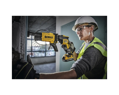 O persoană folosește o șurubelniță cu magazie galbenă DeWalt cu acumulator pentru a înșuruba un șurub într-un perete.