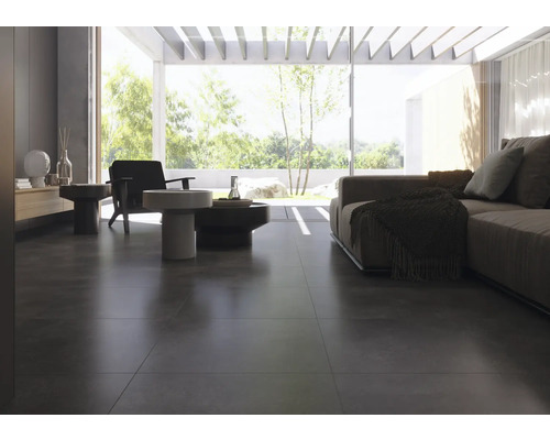 Living luminos cu pardoseală din gresie închisă la culoare, canapea și fotolii