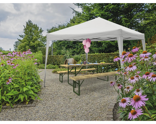 Scenă cu un pavilion, o masă de picnic și flori în grădină