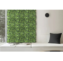 Perete decorativ verde cu plante lângă zona de relaxare cu perne