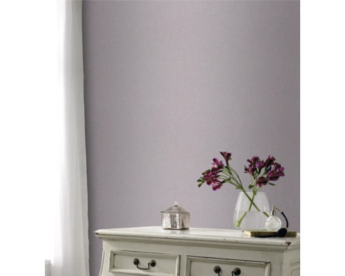 Cameră decorativă cu tapet cu model pe perete, comodă, vază cu flori și perdea la fereastră.