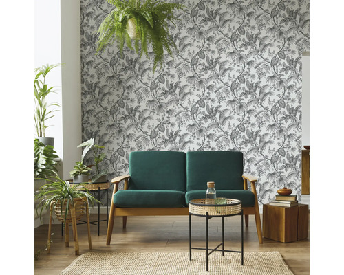 Cameră de zi cu canapea, măsuțe laterale, plante de interior, covor și tapet cu model