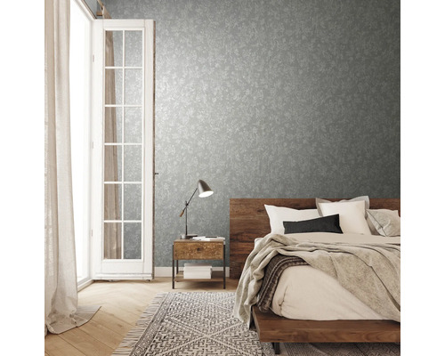 Dormitor cu tapet cu model, pat din lemn și veioză pe noptieră