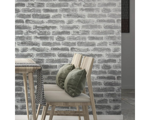 Interior cu tapet de perete cu aspect de piatră, scaune și masă.