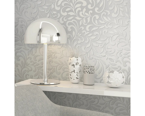 Scenă decorativă cu tapet floral, lampă și vaze pe un raft