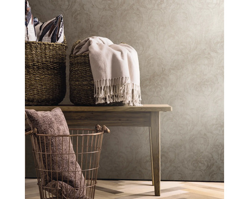 Coșuri decorative și textile pe o masă de lemn în fața unui tapet cu model