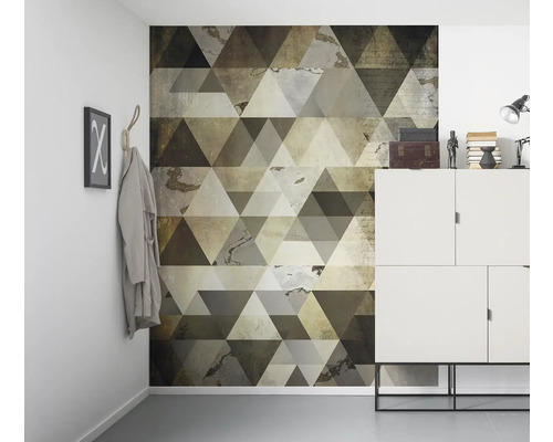 Scenă de cameră cu tapet de perete cu design geometric triunghiular, dulap alb și elemente decorative.