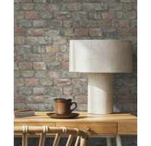 Tapetă decorativă de cărămidă în sufragerie cu lampă de masă și ceașcă.