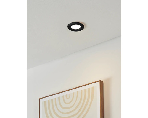 Spot încastrat în tavan într-o cameră cu o imagine pe perete