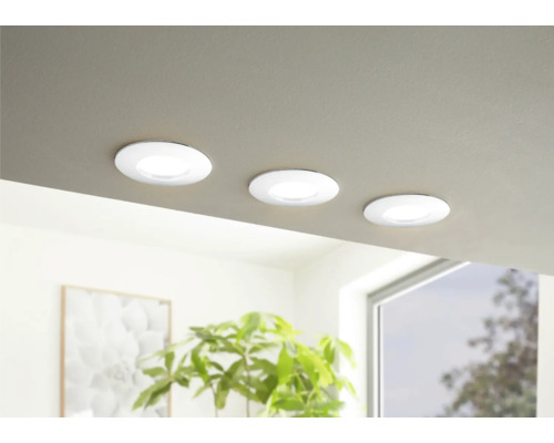 Trei spoturi rotunde, plate, încastrate în tavan, într-o cameră luminoasă