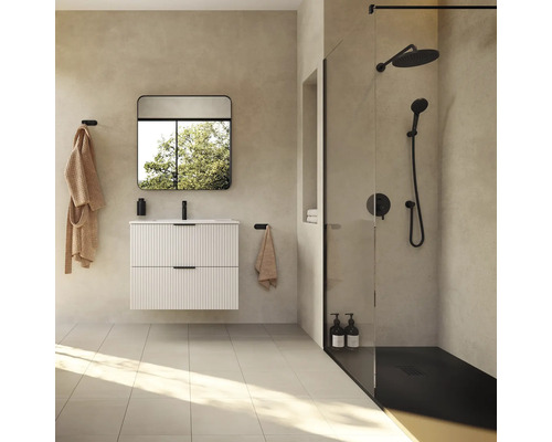 Baie luminoasă cu chiuvetă, oglindă, duș și accesorii de baie.