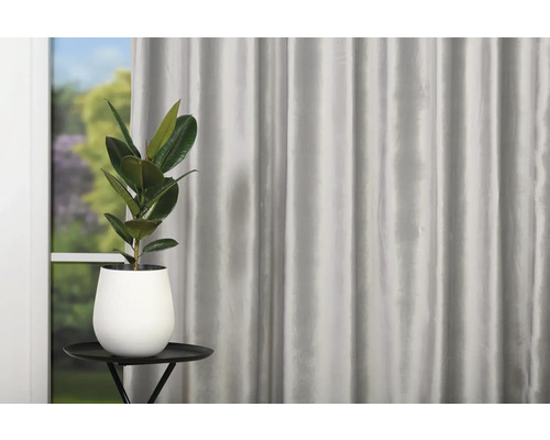 Atmosferă decorativă de locuit cu perdea, masă și plantă la ghiveci