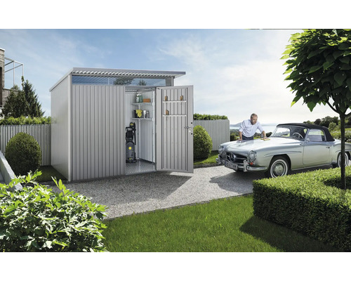 Depozit de grădină metalic cu rafturi, curățător cu presiune și un bărbat care lustruiește o mașină