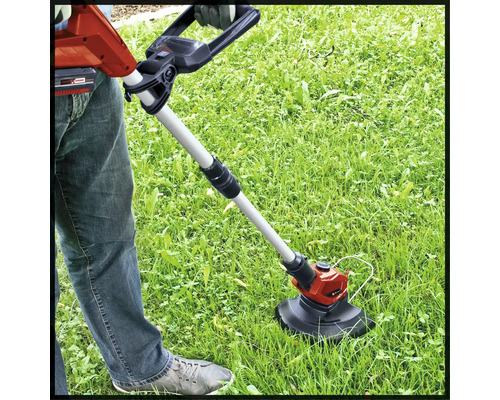 Trimmer de gazon cu acumulator în uz pe un gazon