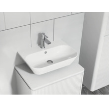 Chiuvetă modernă de baie cu robinet pe un dulap de toaletă cu structură canelată.