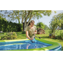 Un bărbat folosește o pompă submersibilă pentru a scoate apa dintr-o piscină din grădină.