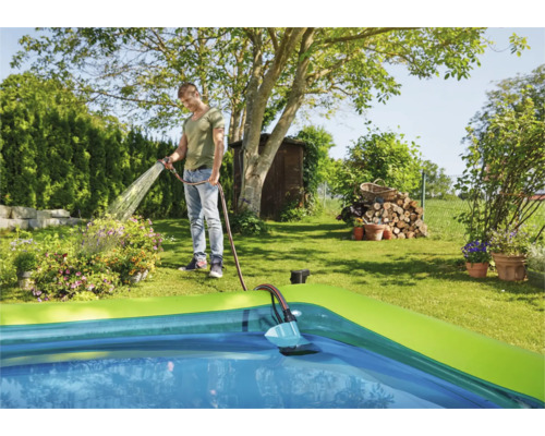 Scenă cu un bărbat umplând o piscină cu un furtun de grădină.