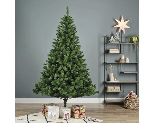 Brad artificial verde de Crăciun cu cadouri în sufragerie.