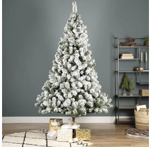 Brad împodobit, cu zăpadă, cu cadouri în sufragerie.