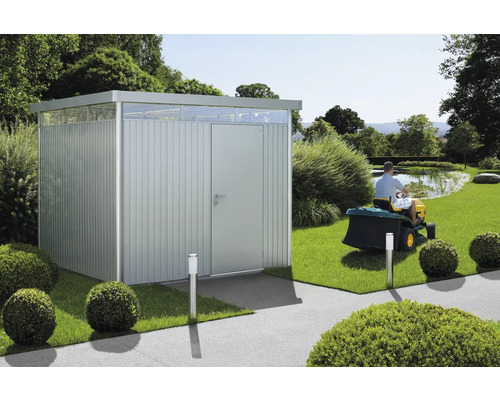 Magazie de grădină metalică cu luminator și un bărbat care tunde gazonul